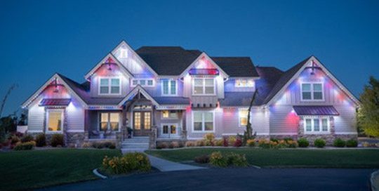 Large estate home fully lit with Bosso Smart Lighting in patriotic red, white, and blue